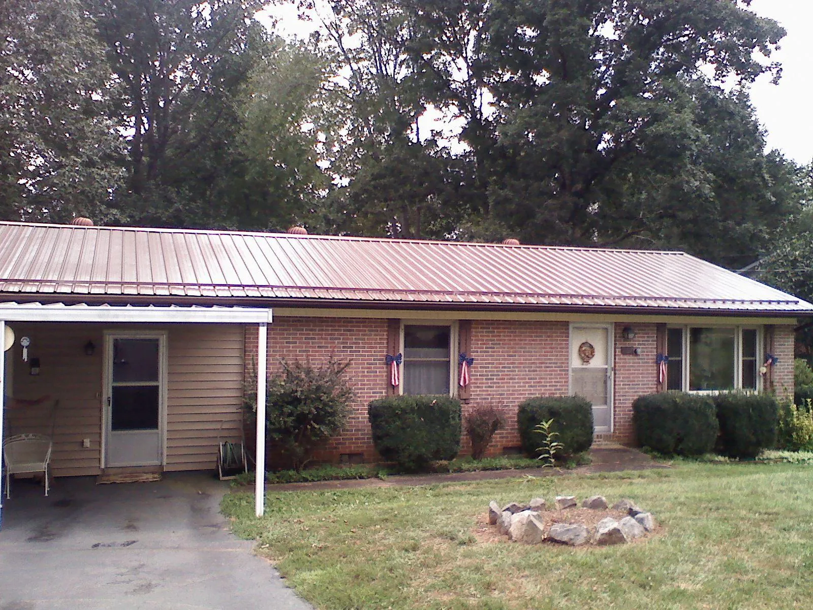 Bronze metal roof and carport on a brick ranch home — Roof Repair work by our crew in Plummer
